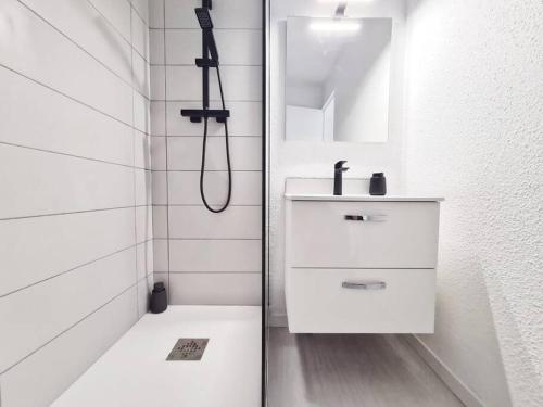 La salle de bains blanche est pourvue d'une douche et d'un lavabo. dans l'établissement TLN-0033 - Le cocon du Cap, à Six-Fours-les-Plages