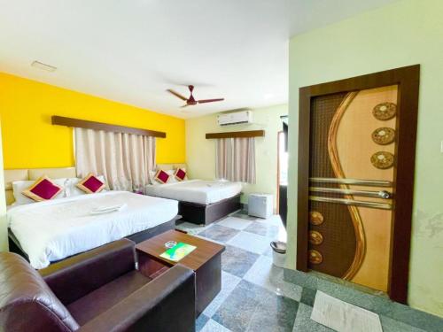 Goroomgo Coral Suites Puri Near Sea Beach with Swimming Pool - Parking Facilities في بوري: غرفه فندقيه بسرير واريكه