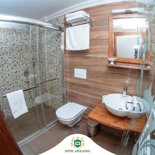 ein Bad mit einer Dusche, einem WC und einem Waschbecken in der Unterkunft Hotel Apollonia in Gjakove