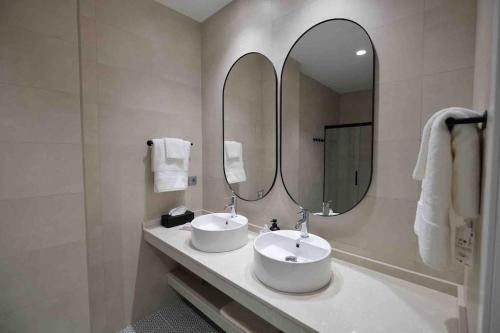 a bathroom with two sinks and a large mirror at CoLet Apartamento in Seville