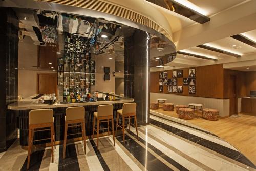 a bar in a restaurant with chairs around it at ARISTA BY AMBITION in Guwahati