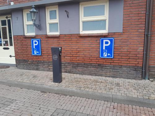dos señales azules de estacionamiento frente a un edificio de ladrillo en Hotel Norg en Norg