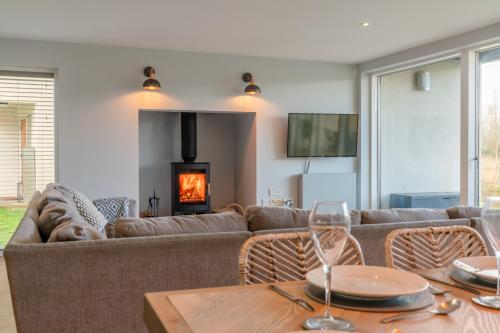 a living room with a couch and a fireplace at Goslings in Somerford Keynes