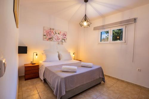 1 dormitorio con 1 cama con 2 toallas en Venetia's Garden en Lefkos Karpathou