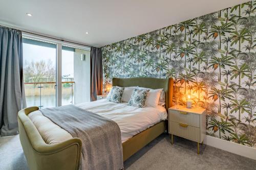 a bedroom with a bed with a tropical wallpaper at Goslings in Somerford Keynes