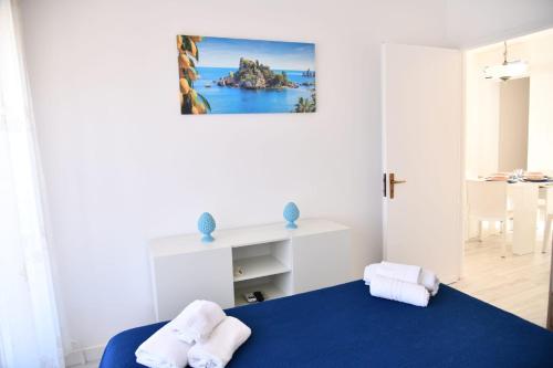 a bedroom with a blue bed with towels on it at BLU HOUSE in Marina di Modica