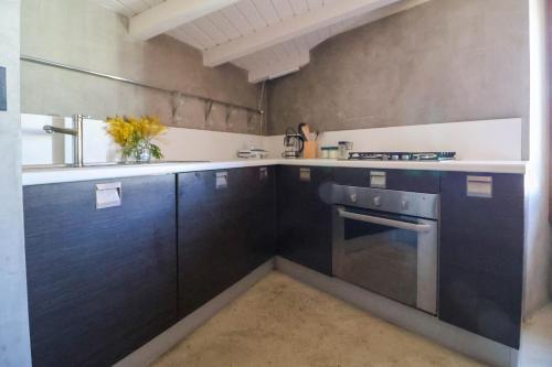 - une cuisine avec des armoires bleu foncé et une cuisinière dans l'établissement La Terrazza Sui Tetti, à Desenzano del Garda