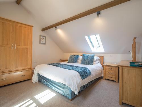 a bedroom with a large bed with blue pillows at Briallen Llanrhystud in Llanrhystyd