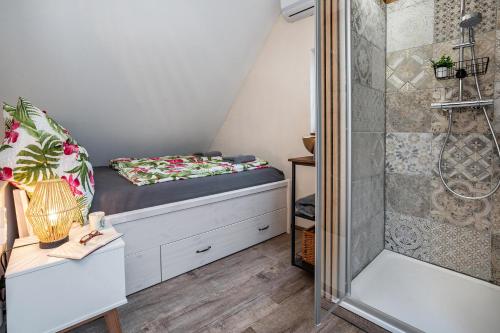 a small attic bedroom with a bed and a shower at Fachwerk in Neustadt an der Weinstraße