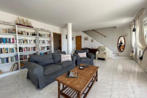 - un salon avec des canapés, une table et des étagères dans l'établissement Breathtaking sea view!, à Frontignan