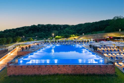 an overhead view of a large swimming pool with chairs at Movenpick Resort and Spa Fruske Terme in Vrdnik