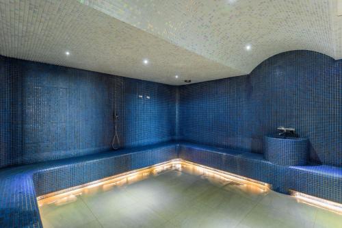a swimming pool in a room with blue tiles at Movenpick Resort and Spa Fruske Terme in Vrdnik