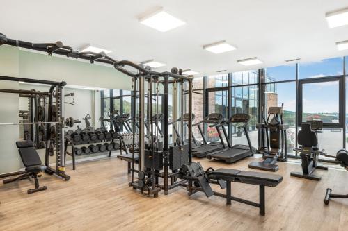 a gym with a lot of treadmills and machines at Movenpick Resort and Spa Fruske Terme in Vrdnik
