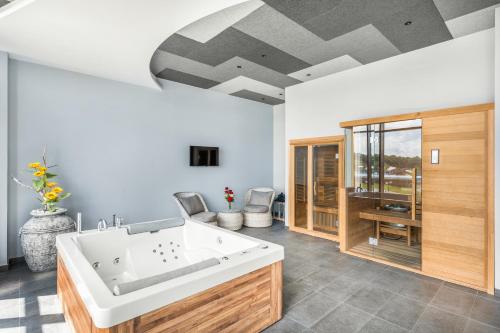 a bathroom with a large white bath tub at Movenpick Resort and Spa Fruske Terme in Vrdnik