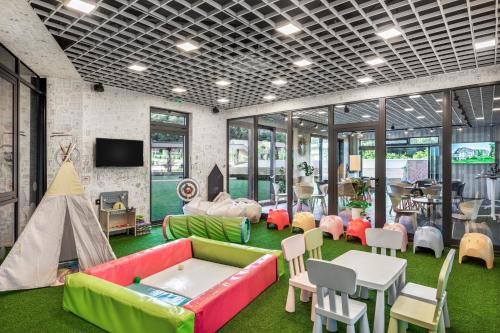 a living room with a couch and a table and chairs at Movenpick Resort and Spa Fruske Terme in Vrdnik