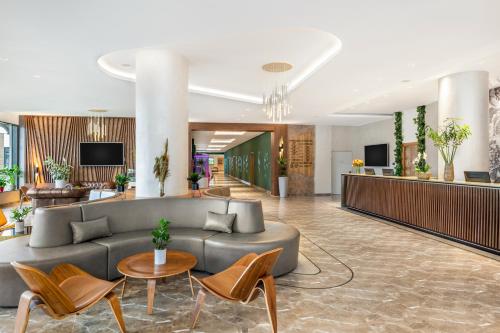 a lobby of a hotel with a couch and chairs at Movenpick Resort and Spa Fruske Terme in Vrdnik