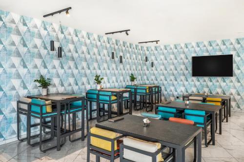 a restaurant with tables and chairs and a flat screen tv at Movenpick Resort and Spa Fruske Terme in Vrdnik