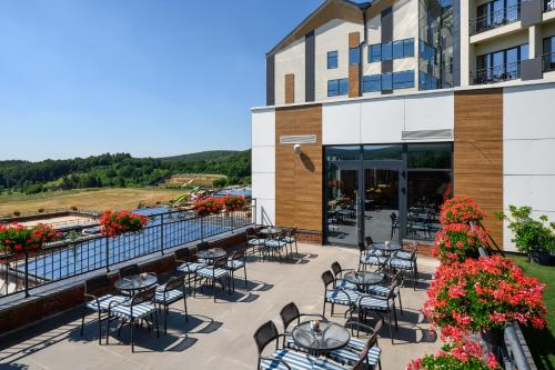a patio with tables and chairs in front of a building at Movenpick Resort and Spa Fruske Terme in Vrdnik