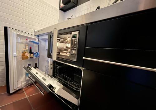 a kitchen with an open oven and a refrigerator at Ferienwohnung Theresia in Garmisch-Partenkirchen