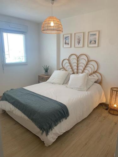 une chambre avec un grand lit blanc avec une grande tête de lit dans l'établissement Seaside spirit, à Frontignan