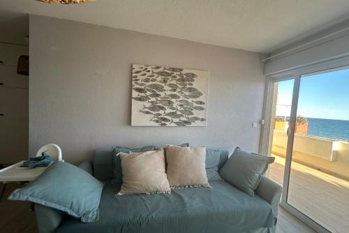 - un canapé bleu dans le salon avec vue sur l'océan dans l'établissement Seaside spirit, à Frontignan