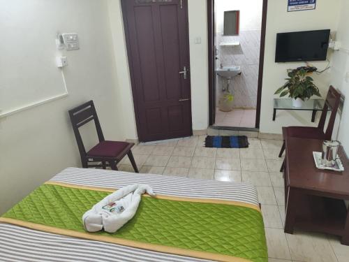 a bedroom with a bed and a desk and a table and chair at Hotel Gamas Inn in Chacka