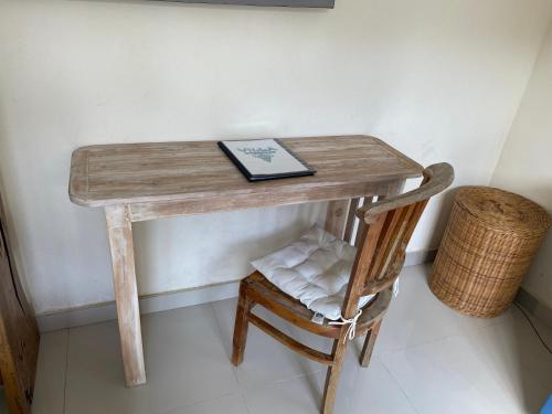 a wooden table with a book and a chair at Villa Viking in Jimbaran