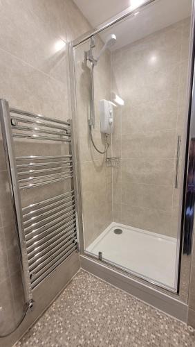 a shower with a glass door in a bathroom at Churston Way Lodge Guest House in Brixham