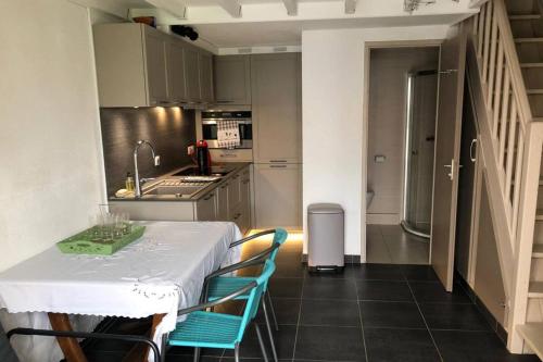 - une cuisine avec une table et des chaises bleues dans la chambre dans l'établissement A stone's throw from the sea!, à Frontignan