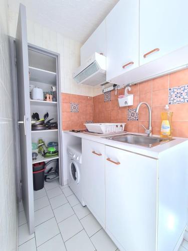 une cuisine blanche avec un évier et un lave-vaisselle dans l'établissement Close to the port and the beach!, à Frontignan