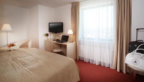 a hotel room with a bed and a window at Clarion Congress Hotel České Budějovice in České Budějovice