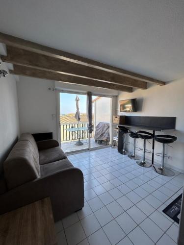 - un salon avec un canapé et un piano dans l'établissement T2 with swimming pool and sea accessair cooled, à Frontignan