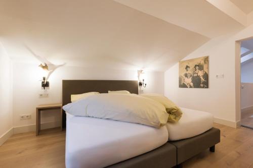 a bedroom with a large white bed in a room at Aparthotel Herzblick GmbH in See