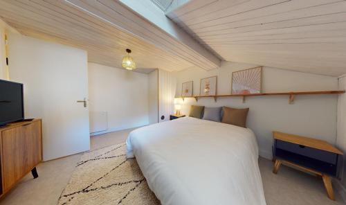 sypialnia z dużym łóżkiem i telewizorem w obiekcie La Mignonette w mieście Rodez