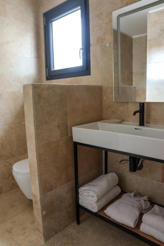 une salle de bain avec un lavabo et un miroir dans l'établissement Résidence La Dolce Vita, à Ghisonaccia