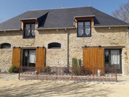 a brick house with a fence in front of it at La Cave "La Villa Saint Martin" in Pontorson