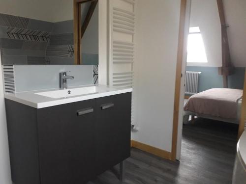 łazienka z umywalką oraz pokój z łóżkiem w obiekcie La Cave "La Villa Saint Martin" w mieście Pontorson