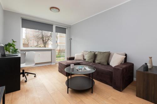 a living room with a couch and a table at Długie Ogrody Spacious Apartment in the Gdańsk City Center by Renters in Gdańsk
