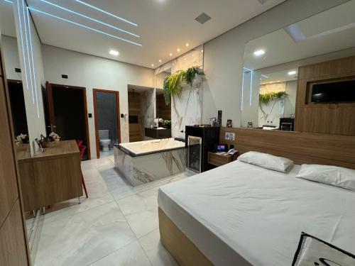 - une chambre avec un lit et une salle de bains pourvue d'une baignoire dans l'établissement Motel Stilo - Adults Only, à Contagem