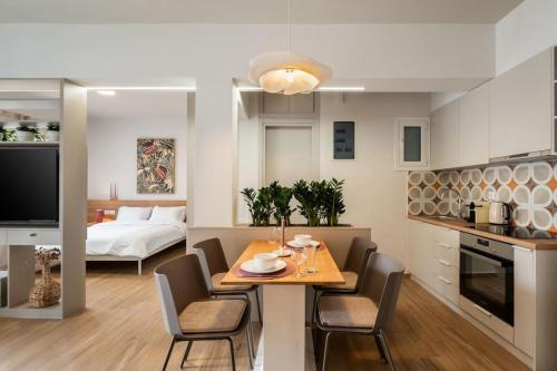 Il comprend une cuisine et un salon avec une table et des chaises. dans l'établissement Glamorous 4th FL Apt in Kolonaki 6 min to Syntagma, à Athènes