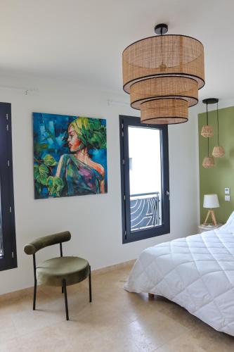 - une chambre avec un lit, une chaise et un tableau dans l'établissement Résidence La Dolce Vita, à Ghisonaccia