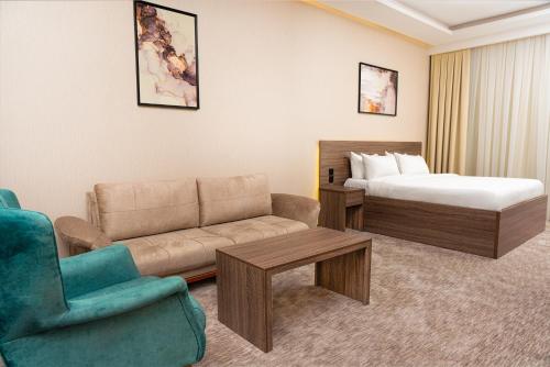 a hotel room with a couch and a bed at فندق بلاتينيوم الاولي الفندقية in Al Madinah