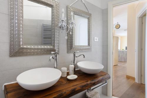a bathroom with two sinks and two mirrors at Amazing view in Tellaro