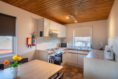 a kitchen with a table and a wooden ceiling at Hunters Quay -3 Bedroom Lodge in Kirn