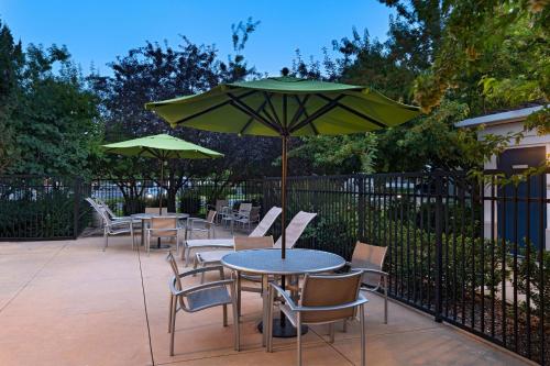 a patio with tables and chairs with green umbrellas at SpringHill Suites Boise West/Eagle in Boise