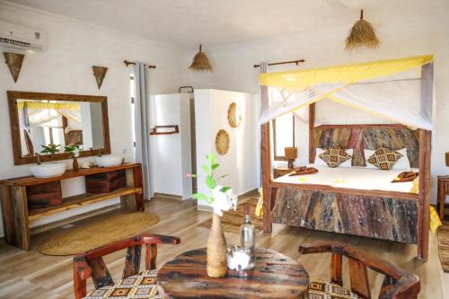 a room with two bunk beds and a table at Z-Lodge Zanzibar in Kiwengwa