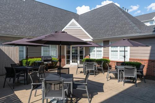a patio with tables and chairs and umbrellas at Residence Inn by Marriott Evansville East in Evansville