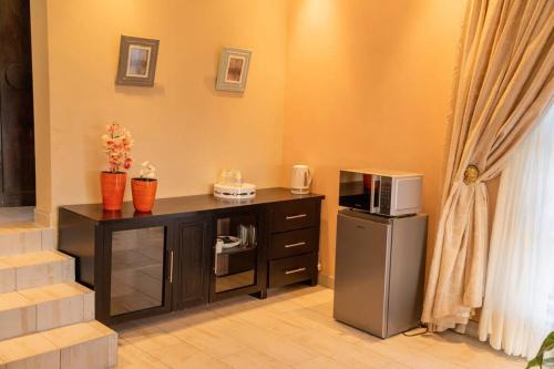 eine Küche mit einer Theke, einer Mikrowelle und einem Kühlschrank in der Unterkunft Gorge View. in Mbabane