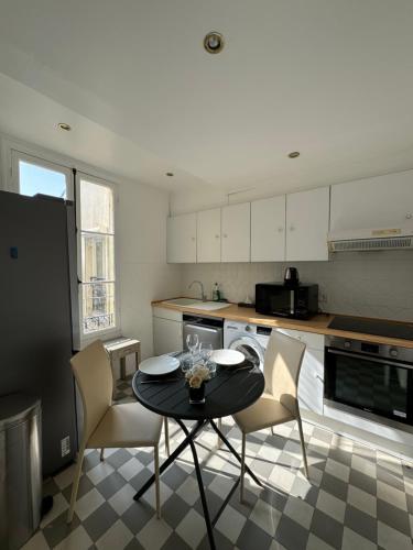 une cuisine avec une table et des chaises dans une cuisine dans l'établissement Aston - Appartement Centre Ville Massena, à Nice