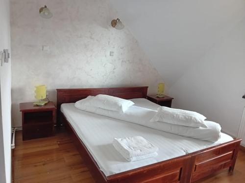 Schlafzimmer mit einem Bett mit weißer Bettwäsche und Kissen in der Unterkunft Rusticanna in Ranca
